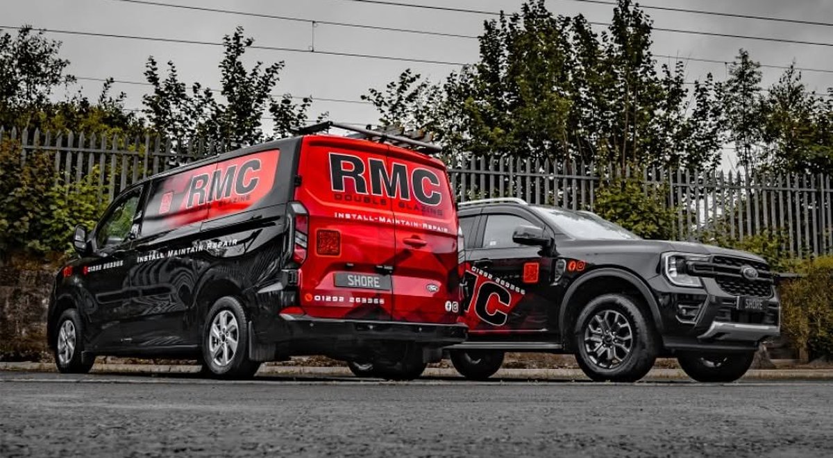 An RMC Double Glazing van and pickup in the company's red and black livery on a cobbled street in Ayr, South Ayrshire Trusted Trader member